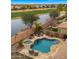 Aerial view showcasing a backyard pool and spa overlooking a serene lake and a verdant golf course at 3400 E Isaiah Ave, Gilbert, AZ 85298