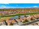 Beautiful aerial view of a residential neighborhood featuring a scenic golf course, pond, and mountain views at 3400 E Isaiah Ave, Gilbert, AZ 85298