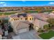 An aerial perspective of a two-story house with solar panels, a three-car garage, desert landscaping, and green lawns at 3400 E Isaiah Ave, Gilbert, AZ 85298