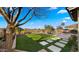 Expansive backyard featuring lush turf, stone patio, black fencing and beautiful water views at 3400 E Isaiah Ave, Gilbert, AZ 85298