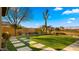 Manicured backyard with synthetic lawn, modern pavers, mature landscaping and an attractive view of the neighborhood at 3400 E Isaiah Ave, Gilbert, AZ 85298