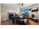 Cozy bedroom features a ceiling fan, dresser, TV, and comfortable chair, creating a relaxing retreat at 3400 E Isaiah Ave, Gilbert, AZ 85298