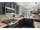 Stylish kitchen with stainless steel gas range, granite counters, dark cabinetry, and pot rack at 3400 E Isaiah Ave, Gilbert, AZ 85298