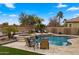 Relaxing backyard with pool, spa, patio seating, manicured landscaping, and a tranquil view of the lake at 3400 E Isaiah Ave, Gilbert, AZ 85298