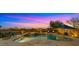 Backyard pool and spa, with a waterfall feature, poolside lounge chairs, and scenic views at dusk at 3400 E Isaiah Ave, Gilbert, AZ 85298