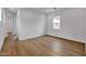 An empty bedroom featuring hardwood floors, white walls, and natural light from a window at 34315 N Sandpiper Trl, Queen Creek, AZ 85144