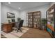 Home office featuring built-in shelving, desk, chair, and hardwood flooring at 34315 N Sandpiper Trl, Queen Creek, AZ 85144