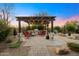 Outdoor kitchen with built-in grill, covered pergola and adjacent seating area at 34801 N 53Rd St # 2, Cave Creek, AZ 85331