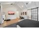 Open bedroom space with a cozy seating area, TV, barn door, and hardwood floors at 3538 E Glenrosa Ave, Phoenix, AZ 85018