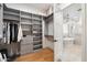 A stunning walk-in closet has gray shelving, wood floors, and flows to an elegant bathroom with a soaking tub at 3538 E Glenrosa Ave, Phoenix, AZ 85018