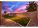 View of the backyard featuring a green lawn, gravel area, and privacy wall at 3768 S Coach House Dr, Gilbert, AZ 85297