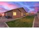 View of the backyard featuring a green lawn, exterior, and an expansive twilight sky at 3768 S Coach House Dr, Gilbert, AZ 85297