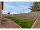 View of the backyard featuring a green lawn, gravel area, and privacy wall at 3768 S Coach House Dr, Gilbert, AZ 85297