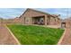 View of the backyard featuring a green lawn, exterior of the home, and covered patio at 3768 S Coach House Dr, Gilbert, AZ 85297