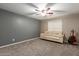 Neutral-toned bedroom showcasing a comfortable sofa, ceiling fan and a guitar near the wall at 3768 S Coach House Dr, Gilbert, AZ 85297