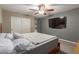 Bedroom with gray walls, white trim, a ceiling fan, and a large mounted television at 3768 S Coach House Dr, Gilbert, AZ 85297