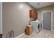 Laundry room with washer, dryer, gray door, and custom wall cabinets at 3768 S Coach House Dr, Gilbert, AZ 85297