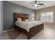 A spacious main bedroom with a decorative wood bed frame, a ceiling fan, and lots of natural light at 3768 S Coach House Dr, Gilbert, AZ 85297