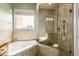 Bathroom with large tiled walk-in shower and soaking tub below a window at 3800 S Cantabria Cir # 1013, Chandler, AZ 85248