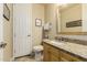 Bathroom features a granite countertop, white sink, wooden cabinets, and a decorative framed mirror at 3800 S Cantabria Cir # 1013, Chandler, AZ 85248