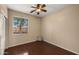 Cozy bedroom with dark laminate floors, ceiling fan, and natural light at 3872 E Flower St, Gilbert, AZ 85298