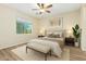 Cozy bedroom showcasing a neutral color scheme, plush bedding, ceiling fan and ample natural light at 42906 W Darter Dr, Maricopa, AZ 85138