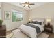 Bedroom with a ceiling fan, plush bedding, neutral tones, and a large window offering natural light at 42906 W Darter Dr, Maricopa, AZ 85138
