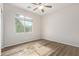 Bright bedroom with a ceiling fan, wood-look floors and a large window at 42906 W Darter Dr, Maricopa, AZ 85138