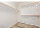 Walk-in closet with white shelving and wood-look flooring at 42906 W Darter Dr, Maricopa, AZ 85138