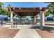 Outdoor sitting area featuring a beautiful pergola-covered patio and picnic tables, perfect for relaxing in the shade at 42906 W Darter Dr, Maricopa, AZ 85138