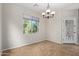 Dining area featuring tile flooring, modern light fixture, door and window with backyard views at 42906 W Darter Dr, Maricopa, AZ 85138