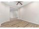 Spacious living room with wood-look floors and a ceiling fan at 42906 W Darter Dr, Maricopa, AZ 85138