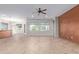 Bright living room with tile floors, ceiling fan, natural light and accent wall at 42906 W Darter Dr, Maricopa, AZ 85138