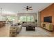 Bright living room features neutral tones, modern furnishings, ceiling fan, and seamless flow to the dining area at 42906 W Darter Dr, Maricopa, AZ 85138