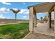 Inviting backyard with a covered patio, offering a serene space with grass and a palm tree at 4473 E Whitehall Dr, San Tan Valley, AZ 85140