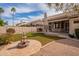 Expansive backyard with a stone fireplace, outdoor kitchen, fountain, and lush landscaping for enjoyable outdoor living at 4552 E Chuckwalla Cyn, Phoenix, AZ 85044