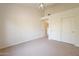 Bright bedroom features neutral walls, carpet flooring, ceiling fan, and access to another room at 4552 E Chuckwalla Cyn, Phoenix, AZ 85044