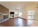 Bright living room featuring a stone fireplace, wood floors, built-in shelves, and sliding glass doors at 4552 E Chuckwalla Cyn, Phoenix, AZ 85044