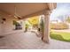 Inviting covered patio featuring a stone fireplace, fan, and tile flooring, perfect for outdoor relaxation and entertaining at 4552 E Chuckwalla Cyn, Phoenix, AZ 85044