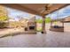 Outdoor covered patio featuring stone fireplace, built-in grill, tiled flooring, and ceiling fan at 4552 E Chuckwalla Cyn, Phoenix, AZ 85044