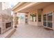 Outdoor covered patio featuring stone fireplace, tiled flooring, and backyard access at 4552 E Chuckwalla Cyn, Phoenix, AZ 85044