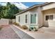 Home exterior with a sidewalk, green plants, white windows, an irrigation can and gate at 4725 E Brown Rd # 59, Mesa, AZ 85205