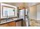 Well-lit kitchen featuring stainless steel appliances, wood cabinets, stone backsplash, and a window overlooking the backyard at 4725 E Brown Rd # 59, Mesa, AZ 85205