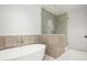 Modern bathroom with a freestanding tub and glass shower, all adorned with neutral-toned tiling at 5000 N Camelback Ridge Rd # 210, Scottsdale, AZ 85251