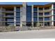 Modern building with a combination of stone and concrete, featuring multiple balconies and large windows at 5000 N Camelback Ridge Rd # 210, Scottsdale, AZ 85251