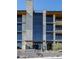 Modern building entrance with stone accents, wood soffits, and large windows at 5000 N Camelback Ridge Rd # 210, Scottsdale, AZ 85251