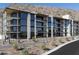 Contemporary building with modern design elements, balconies, and desert landscaping against a mountain backdrop at 5000 N Camelback Ridge Rd # 210, Scottsdale, AZ 85251