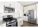 Bright kitchen featuring white cabinets, granite countertops, stainless steel appliances, and wood flooring at 5100 E Rancho Paloma Dr # 2024, Cave Creek, AZ 85331