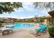 Community pool area with numerous lounge chairs and umbrella tables under a partly cloudy sky at 5100 E Rancho Paloma Dr # 2024, Cave Creek, AZ 85331