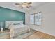 Cozy bedroom with a serene green accent wall, wood floors, and a ceiling fan for year round comfort at 5206 W Desert Hills Dr, Glendale, AZ 85304